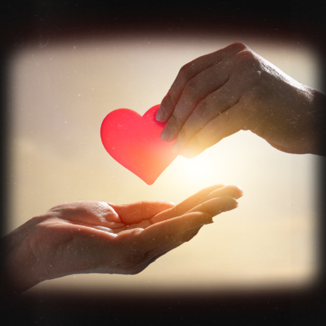 Spenden mit Herz Eine Hand übergibt einer anderen ein Herz. Im Hintergrund strahlt die Sonne.