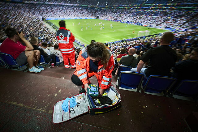 Einsatz des DRK bei der Fußball-Europameisterschaft 2024 in Deutschland. Hier beim Spiel Spanien - Italien in der Arena auf Schalke in Gelsenkirchen. Sanitätsdienst mit Notfallrucksack im Stadion während des Spiels